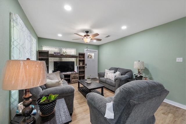 living room featuring ceiling fan and light hardwood / wood-style flooring