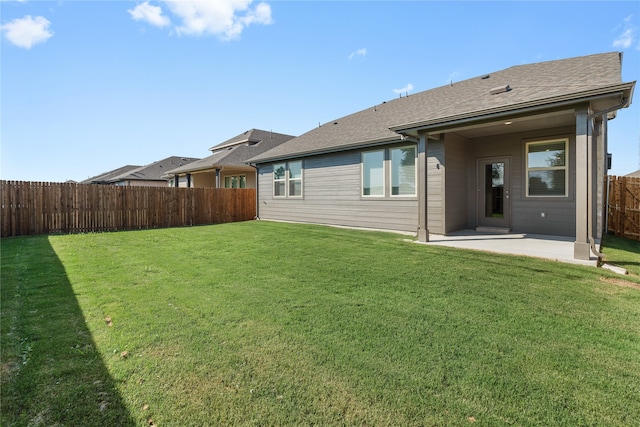 rear view of house with a patio and a yard