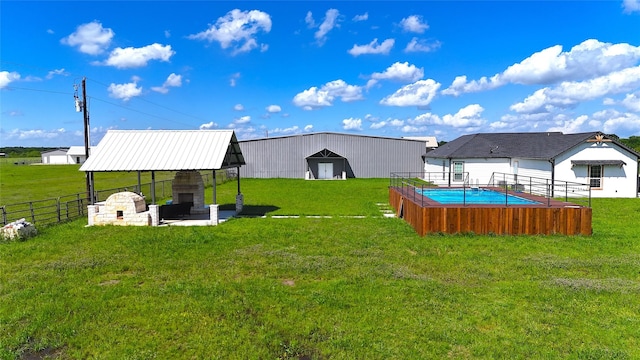 view of yard featuring a patio area, a fireplace, fence, and a fenced in pool