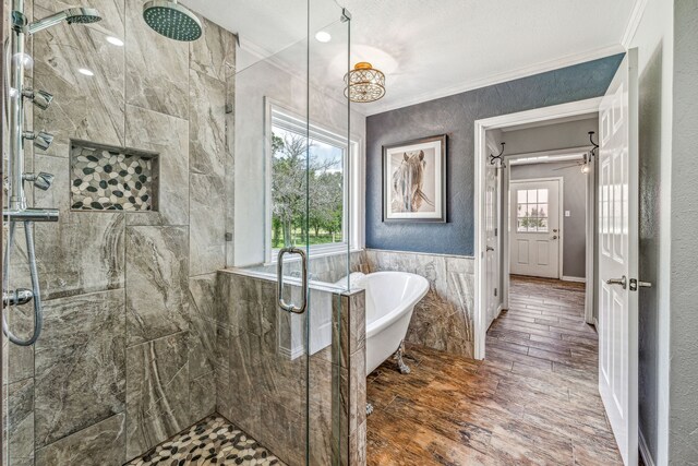 bathroom featuring ornamental molding, a wealth of natural light, and separate shower and tub