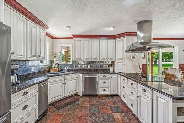 kitchen with island exhaust hood, a wealth of natural light, dark tile floors, and appliances with stainless steel finishes