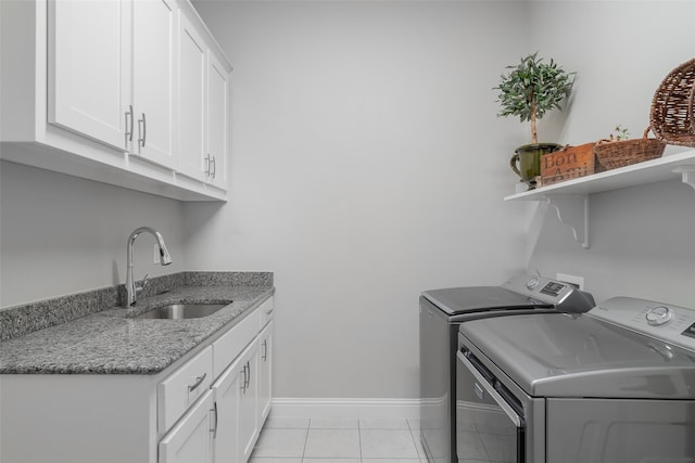 laundry room with sink, light tile patterned floors, cabinets, and independent washer and dryer