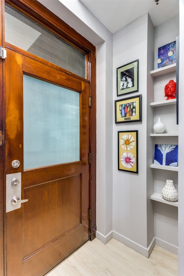 doorway featuring light hardwood / wood-style floors and built in features