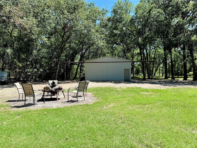 view of yard featuring an outbuilding, a pole building, and a fire pit