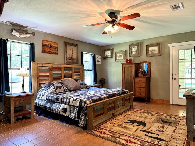 tiled bedroom featuring a textured ceiling, ceiling fan, and access to exterior