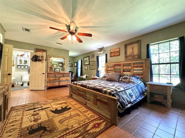 tiled bedroom with ceiling fan and a textured ceiling