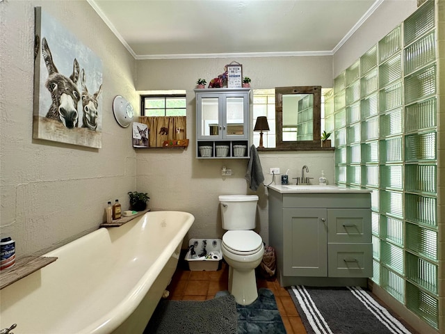 bathroom with ornamental molding, tile floors, a washtub, vanity, and toilet