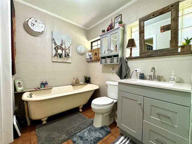 bathroom featuring crown molding, tile floors, a washtub, toilet, and vanity