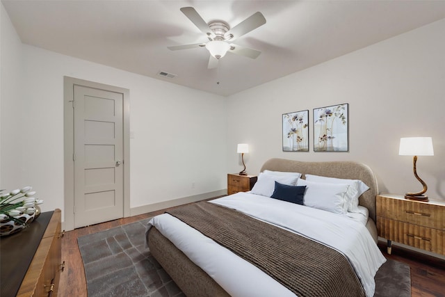 bedroom featuring a ceiling fan, visible vents, baseboards, and wood finished floors