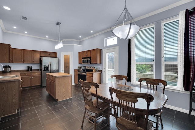 tiled dining room featuring sink and ornamental molding