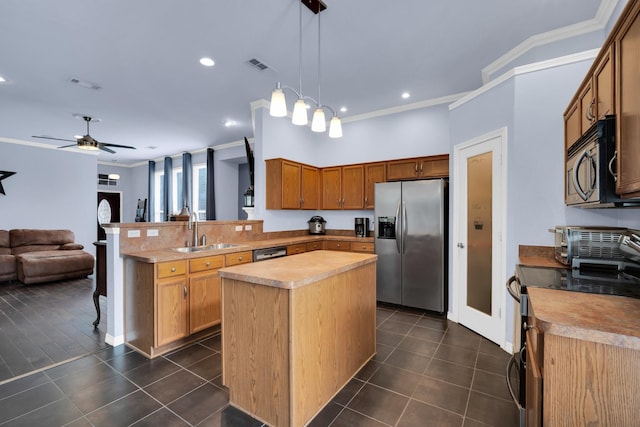 kitchen featuring pendant lighting, a center island, stainless steel appliances, sink, and kitchen peninsula