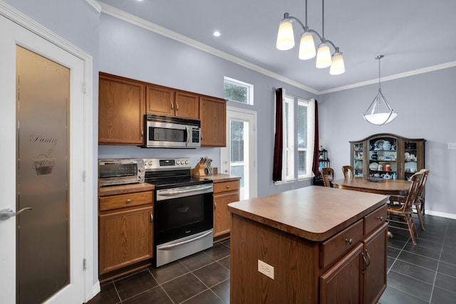 kitchen featuring appliances with stainless steel finishes, dark tile patterned floors, a kitchen island, and decorative light fixtures