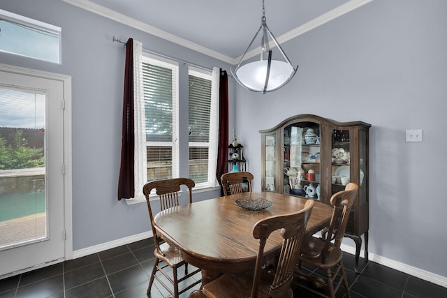 dining area featuring crown molding and dark tile patterned floors