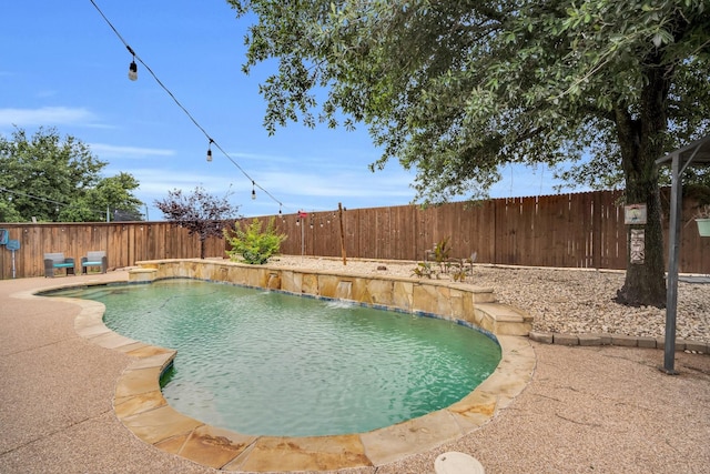 view of swimming pool featuring pool water feature and a patio