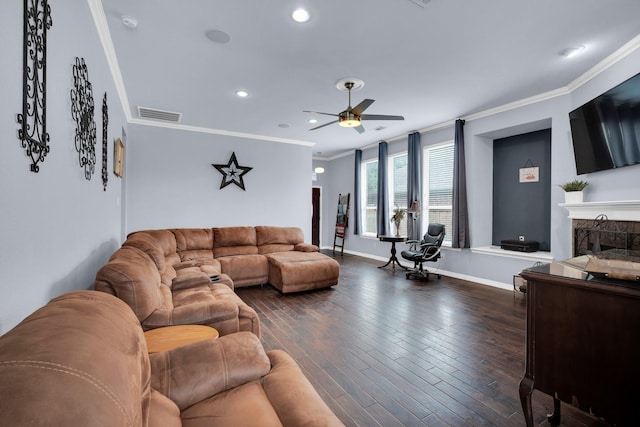 living room with ceiling fan, a high end fireplace, dark hardwood / wood-style floors, and crown molding