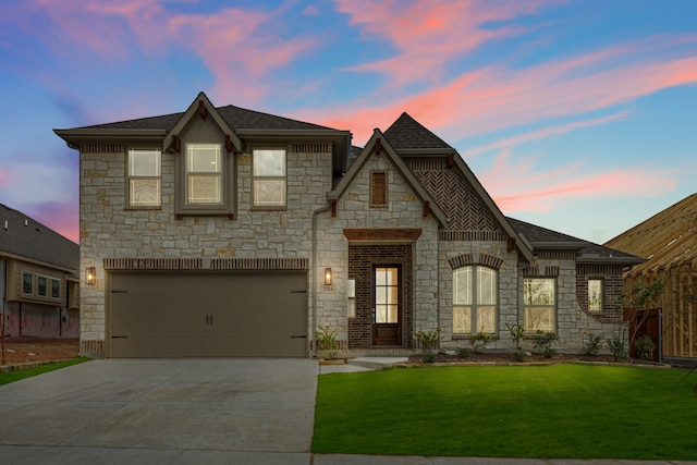 french provincial home featuring a garage and a lawn