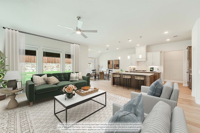 living room featuring light hardwood / wood-style flooring and ceiling fan