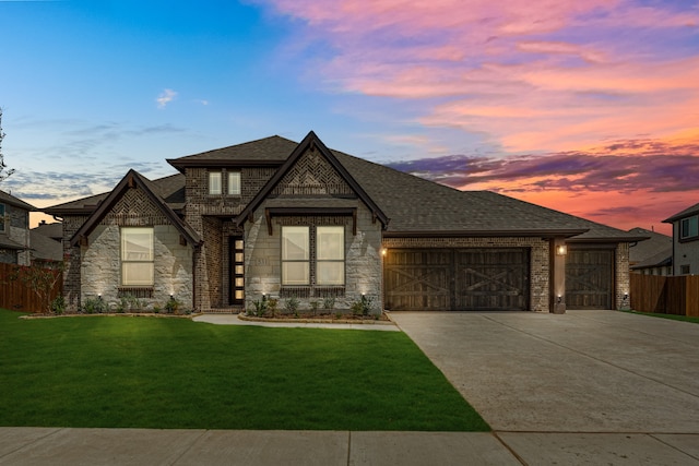 view of front of home with a garage and a yard