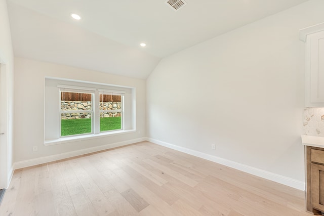 empty room featuring lofted ceiling and light wood-type flooring