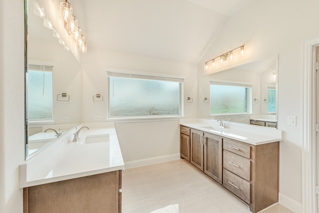 bathroom with vanity, vaulted ceiling, and tile patterned flooring