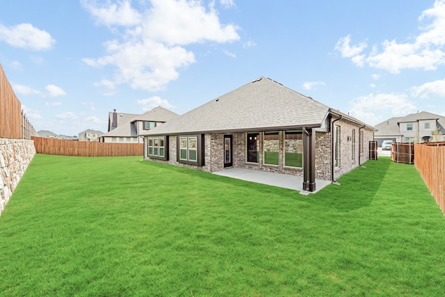 back of house featuring a lawn and a patio area