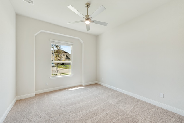 spare room featuring light colored carpet and ceiling fan