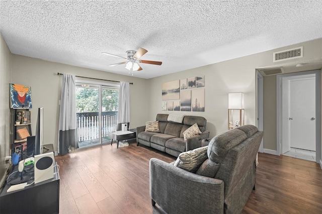 living room featuring ceiling fan, dark hardwood / wood-style flooring, and a textured ceiling