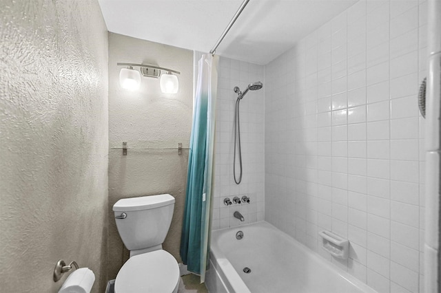 bathroom featuring shower / tub combo and toilet