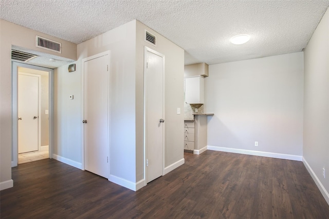 hallway featuring dark hardwood / wood-style floors and a textured ceiling