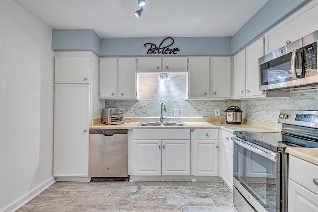 kitchen featuring decorative backsplash, sink, white cabinets, and stainless steel appliances