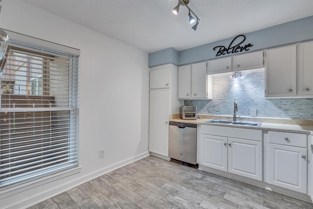 kitchen featuring dishwasher, white cabinets, sink, a textured ceiling, and light hardwood / wood-style floors