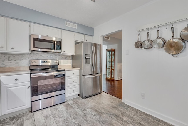 kitchen featuring white cabinets, appliances with stainless steel finishes, and tasteful backsplash