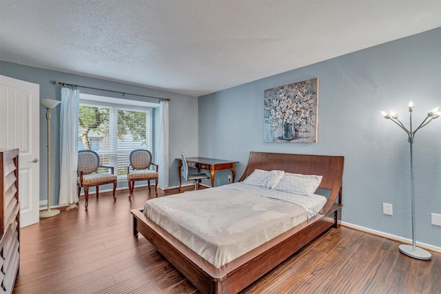 bedroom featuring dark wood-type flooring and a textured ceiling