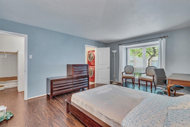 bedroom featuring dark hardwood / wood-style flooring, a textured ceiling, a spacious closet, and a closet