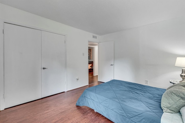 bedroom with hardwood / wood-style flooring and a closet