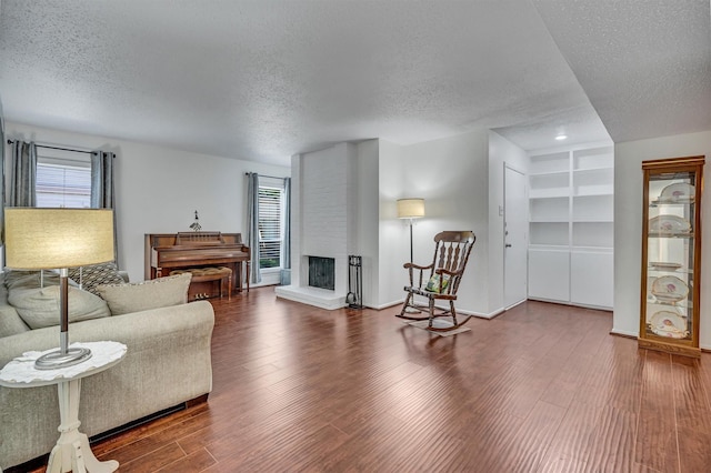 living room featuring hardwood / wood-style flooring, a multi sided fireplace, and a textured ceiling