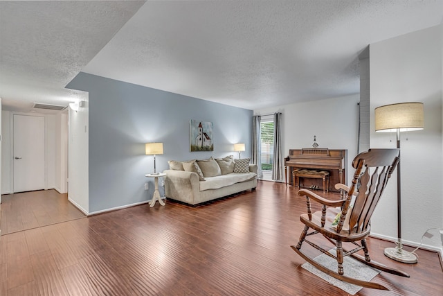 living room with hardwood / wood-style floors and a textured ceiling