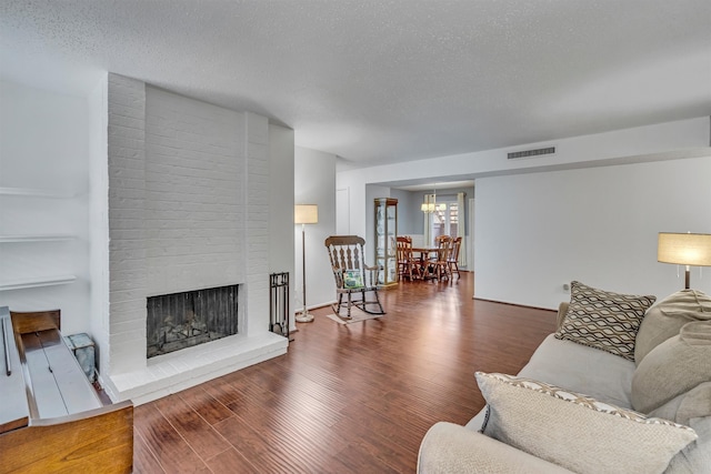 living room with a textured ceiling, dark hardwood / wood-style flooring, and a fireplace