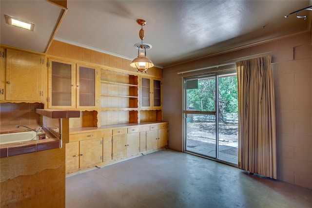 interior space with pendant lighting, concrete floors, and tile counters