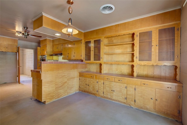 kitchen with under cabinet range hood, a peninsula, visible vents, finished concrete flooring, and ornamental molding