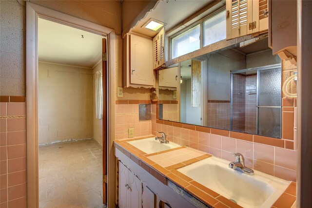 bathroom featuring dual vanity, backsplash, tile patterned floors, and tile walls