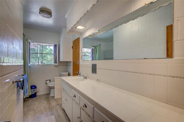 full bathroom with curtained shower, toilet, wood finished floors, vanity, and tile walls