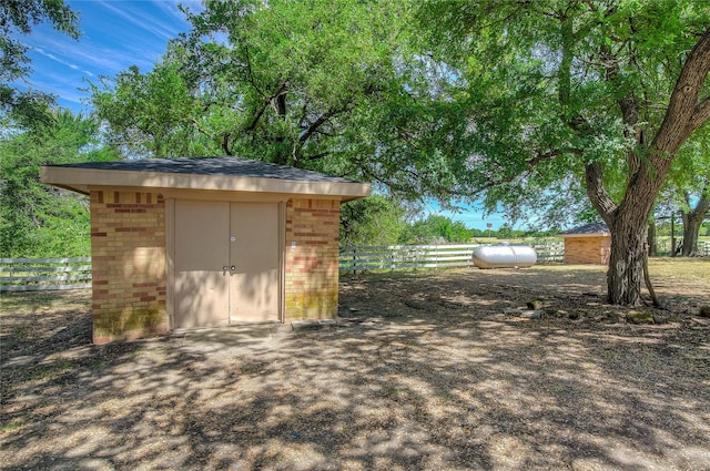 view of shed with a garage and fence