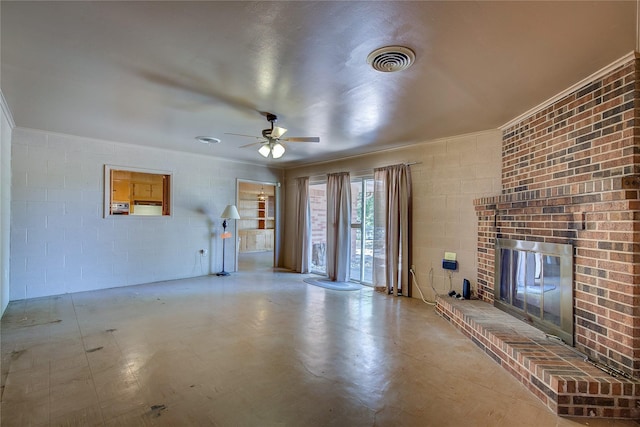 unfurnished living room with ceiling fan, a fireplace, visible vents, and concrete block wall