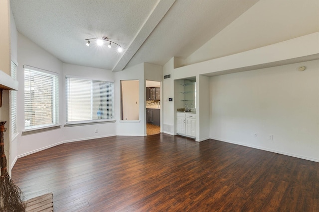 unfurnished living room featuring a textured ceiling, dark hardwood / wood-style floors, lofted ceiling, and sink