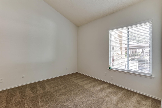 empty room featuring carpet floors and vaulted ceiling