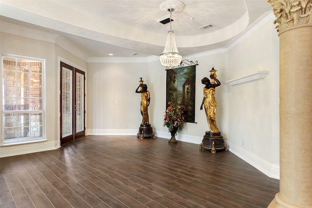 spare room with a tray ceiling, decorative columns, plenty of natural light, and dark wood-type flooring