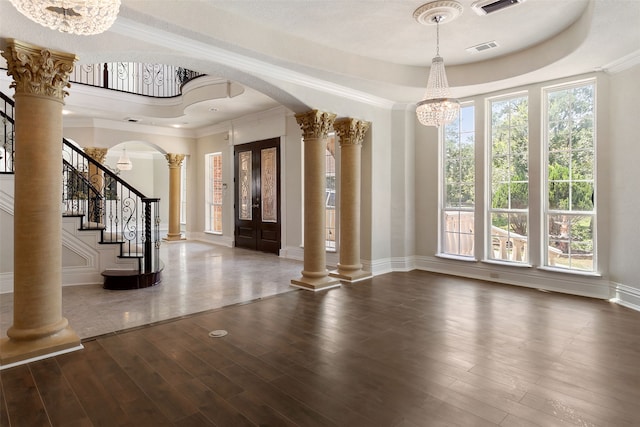 entryway with hardwood / wood-style flooring, a tray ceiling, and decorative columns