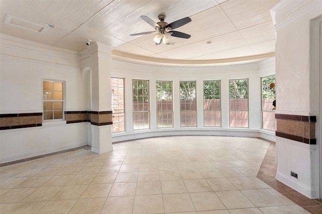 tiled empty room featuring a tray ceiling and ceiling fan