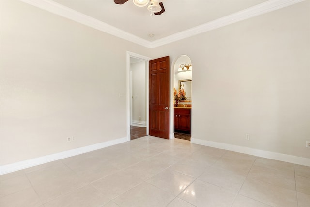 tiled spare room with ornamental molding and ceiling fan